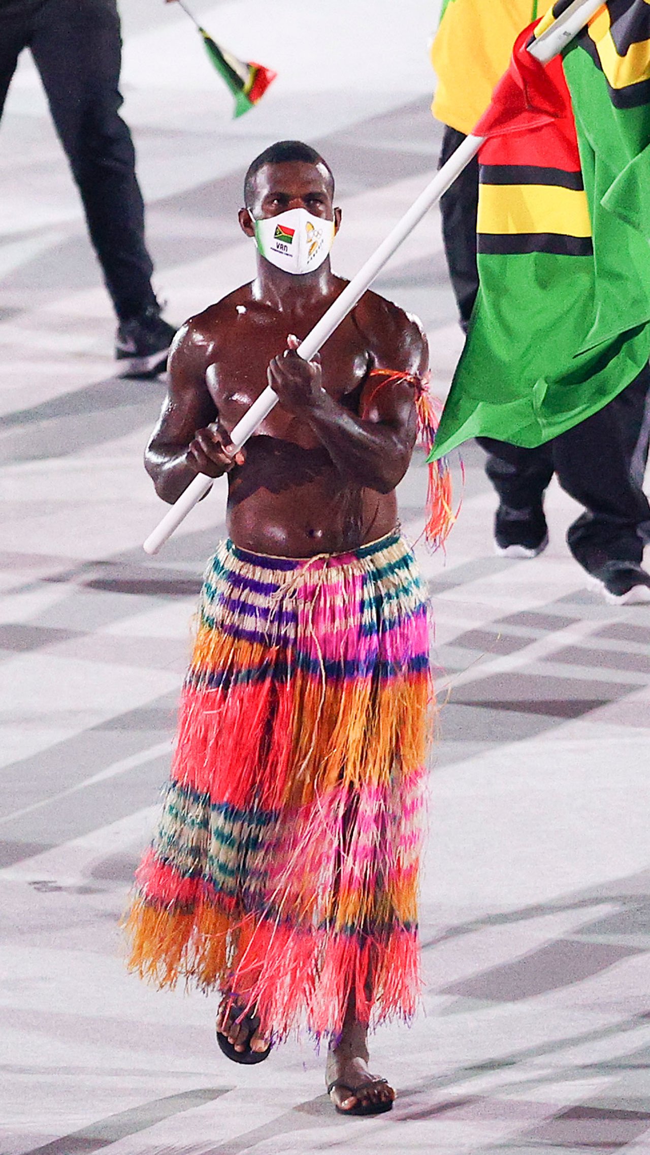 А вот знаменосец Вануату пришёл в разноцветной юбке в пол, а сам был обмазан маслом!